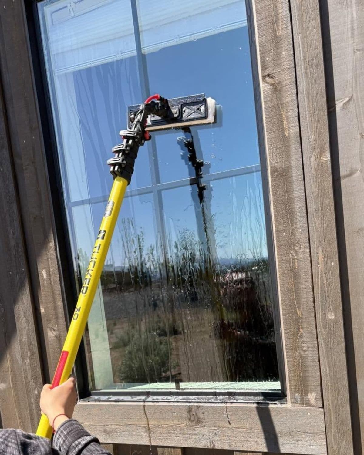 Restored clear glass window after hard water stain removal treatment